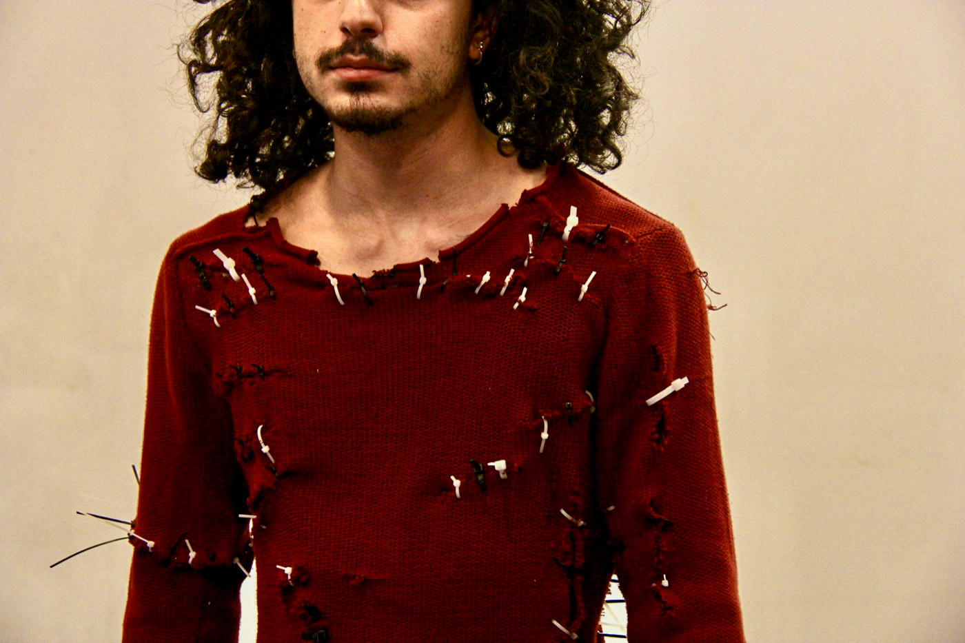 Close view of Cope, showing the torn red garment joined with black and white cable ties